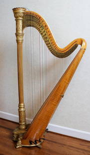 Lyon & Healy Tiger Maple and Gilt Wood Harp: Lyon & Healy tiger maple and gilt wood harp with geometric accenting and pedals. Based on the serial no. 2648, this harp was made around 1925. Size: 5'10"h x 35"d x 19"w Location: Dining Room