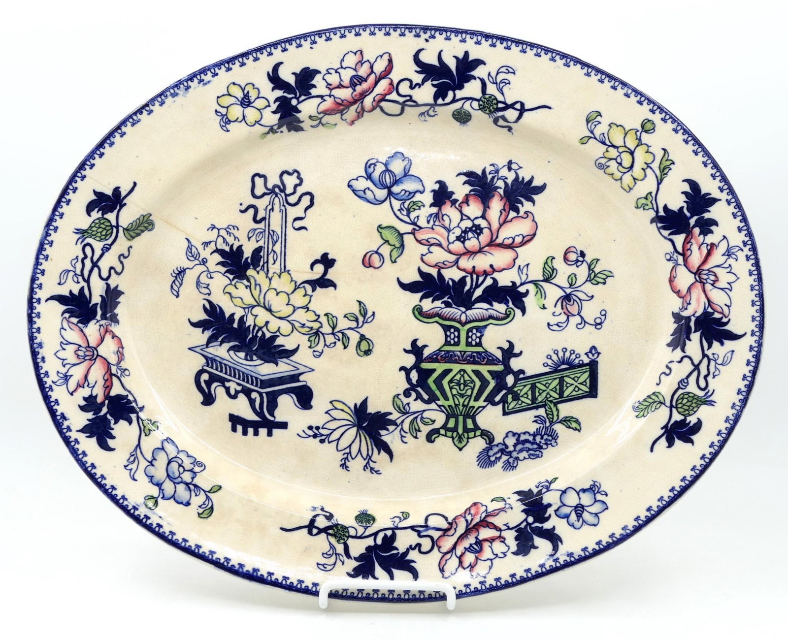 English Chinoiserie Ironstone Platter: Circa late 19th century English ironstone platter featuring chinoiserie design. Crack along the center. Piece is not marked. Discoloration throughout. Size: 18.25"w