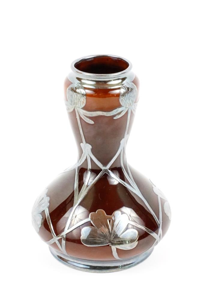 Silver Overlay Art Nouveau Bud Vase: Silver overlay Art Nouveau bud vase marked with a Hippocampus/Kelpie emblem, the letter M England. Mauser Manufacturing Co. Circa 1887-1903. Size: 3.5"h Location: Dining Room