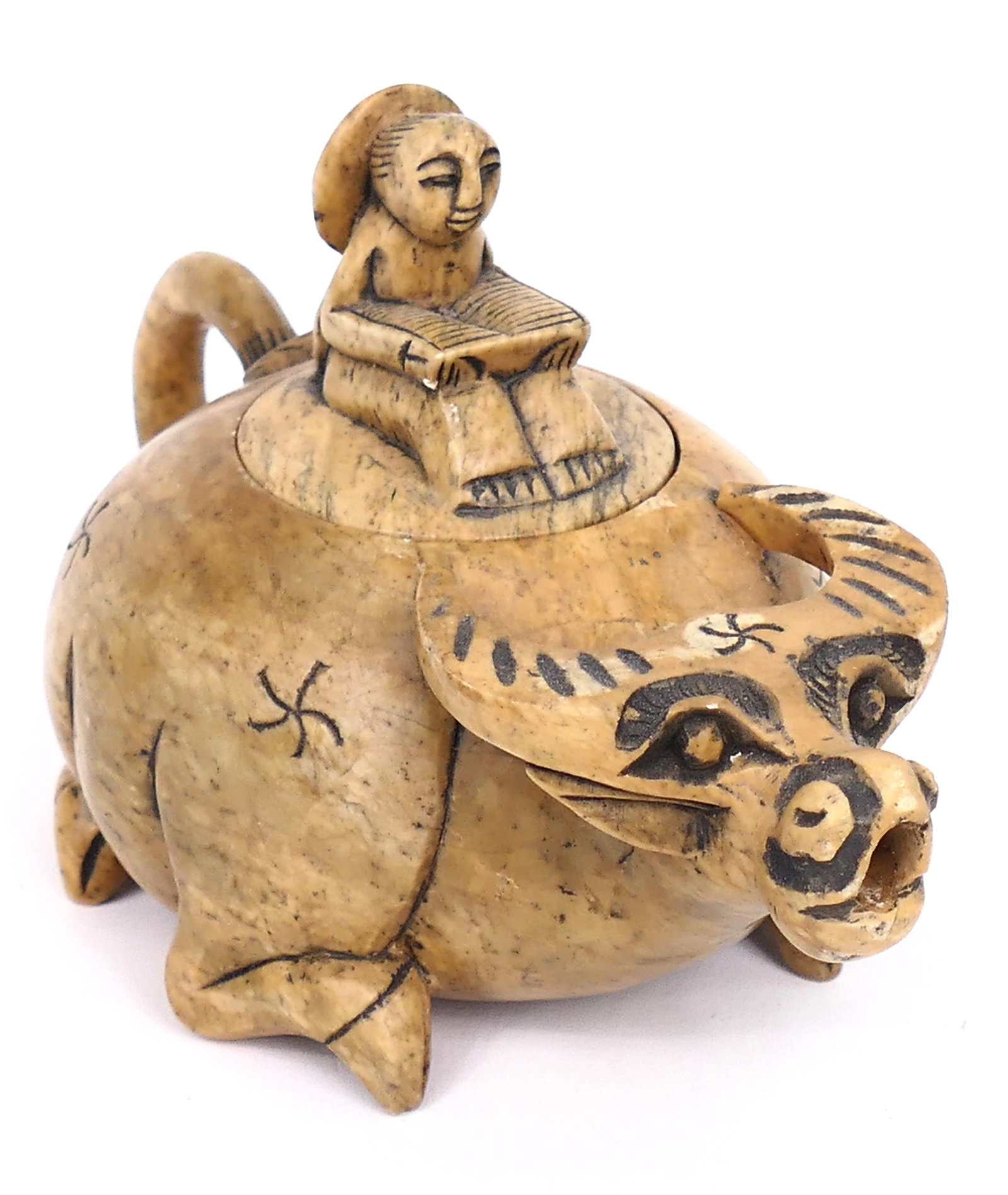 Hand Carved Water Buffalo Teapot: Vintage hand carved soapstone water buffalo teapot featuring a design of a young boy riding atop while reading a book. Ear shows a small chip. Size: 6"w x 4"h