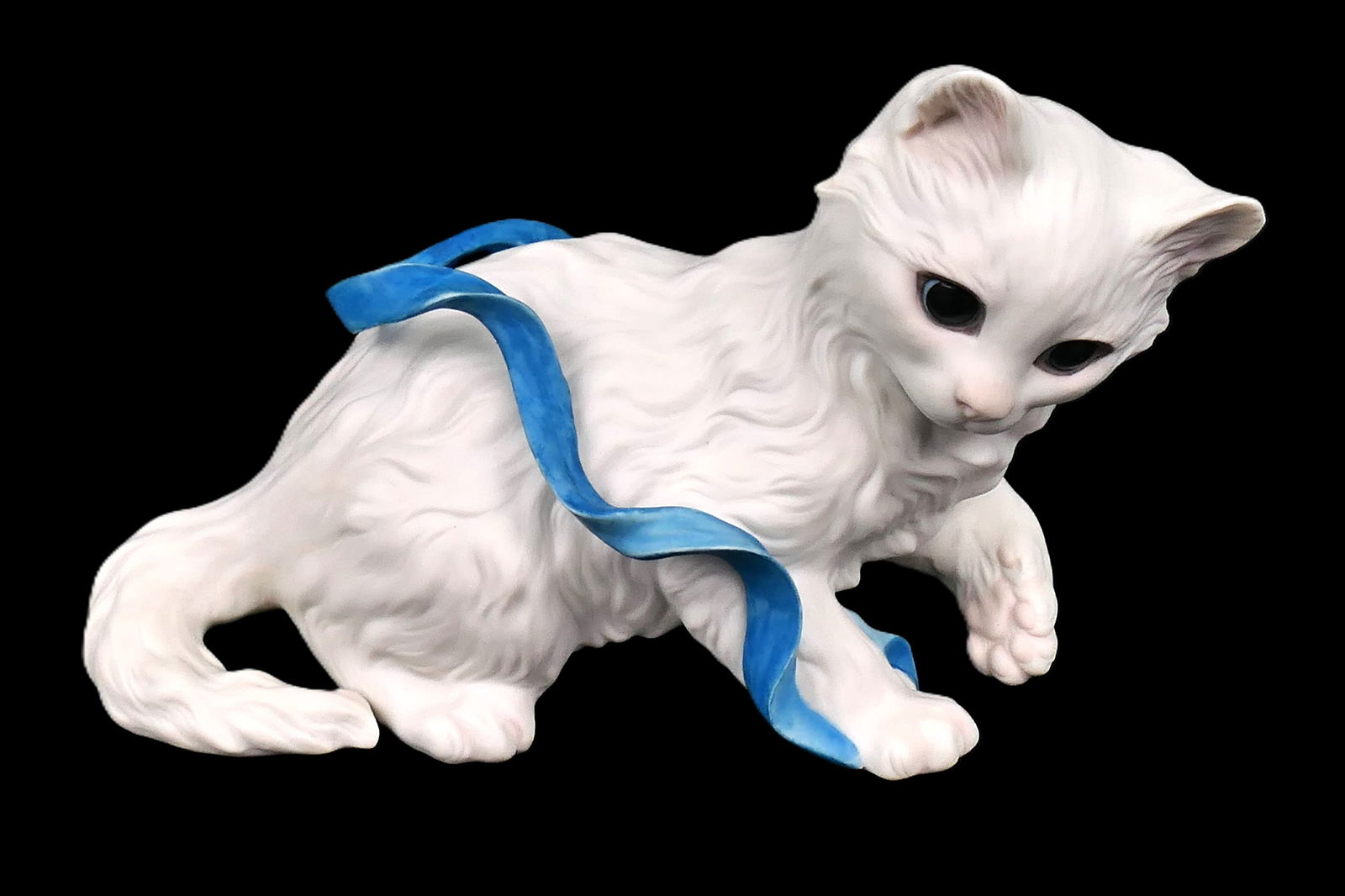 Cybis "Kitten With The Blue Ribbon" Figurine: White porcelain figurine by Cybis titled "Kitten with the Blue Ribbon", signed on one paw. The ribbon appears to have been cracked and repaired in one place, and the tail appears to be slightly cracke