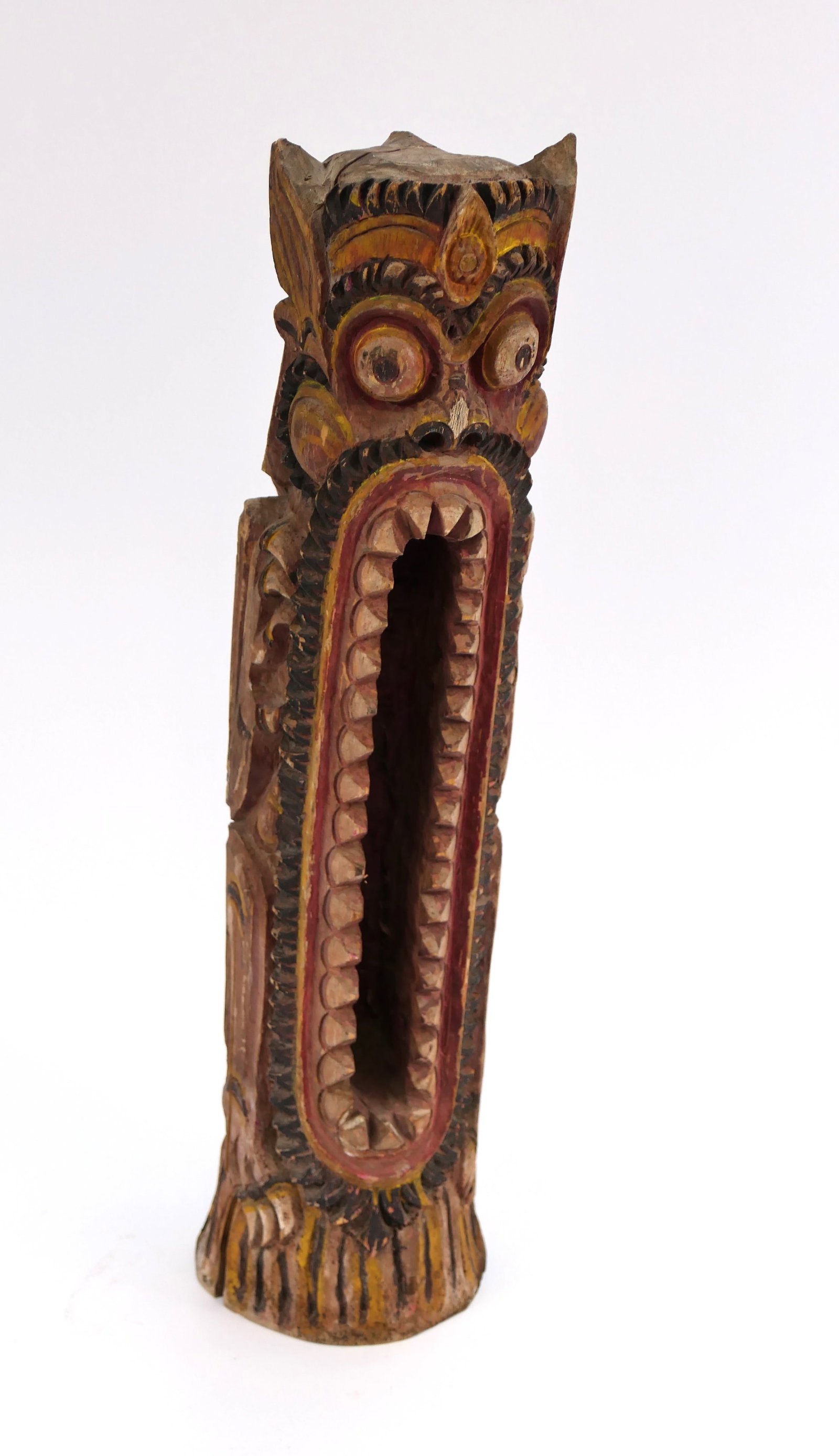 Hand Carved Siren Slit Drum: Hand carved Balinese-style Siren slit drum, featuring an elongated, toothy, monstrous design. Surfaces show finish wear and scratches from age. The base shows a wood split. Size: 21"h