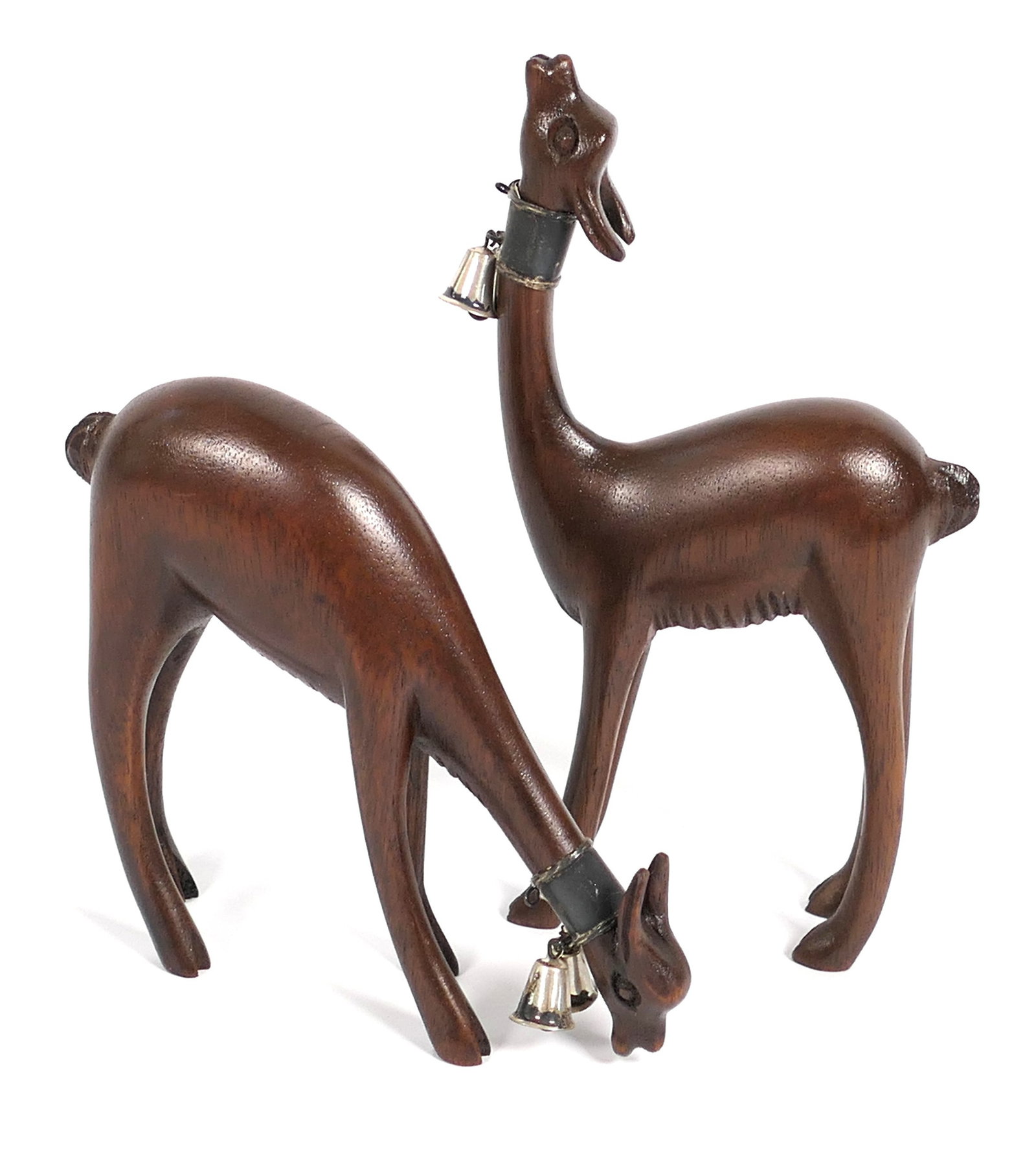 Two Cedar Vicuna Figures: Two cedar wood vicuna figurines adorned with sterling silver bells, fabricated in Peru. They are marked on the bellies with plaques reading "A&K". Size: 5.75"h Location: Dining Room