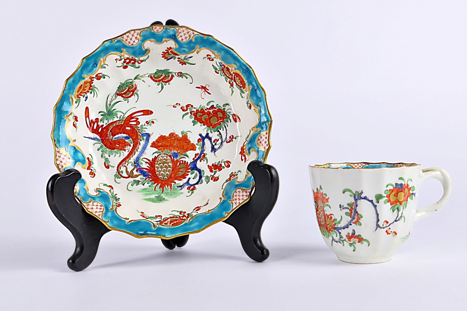 Worcester Jabberwocky Teacup and Saucer: Circa 18th century Worcester porcelain pieces including a teacup and saucer in the Jabberwocky pattern, featuring chinoiserie motifs with gilt and teal accents. Pieces are marked on the bases with Wor