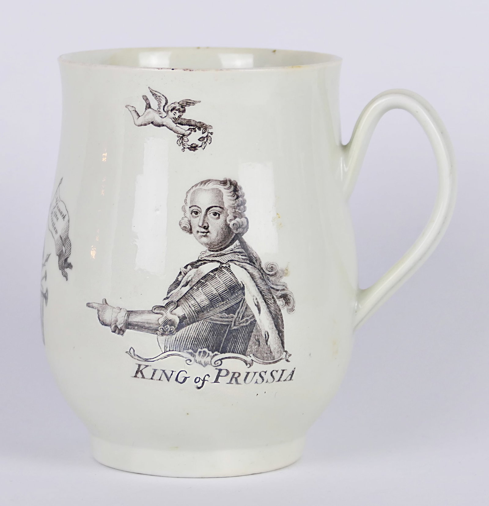 Antique King of Prussia Mug: Circa 18th century King of Prussia mug featuring printed imagery of his battles, and heraldic angels. This piece is marked near the battle motif "RH" for engraver Robert Hancock, along with "Worcester