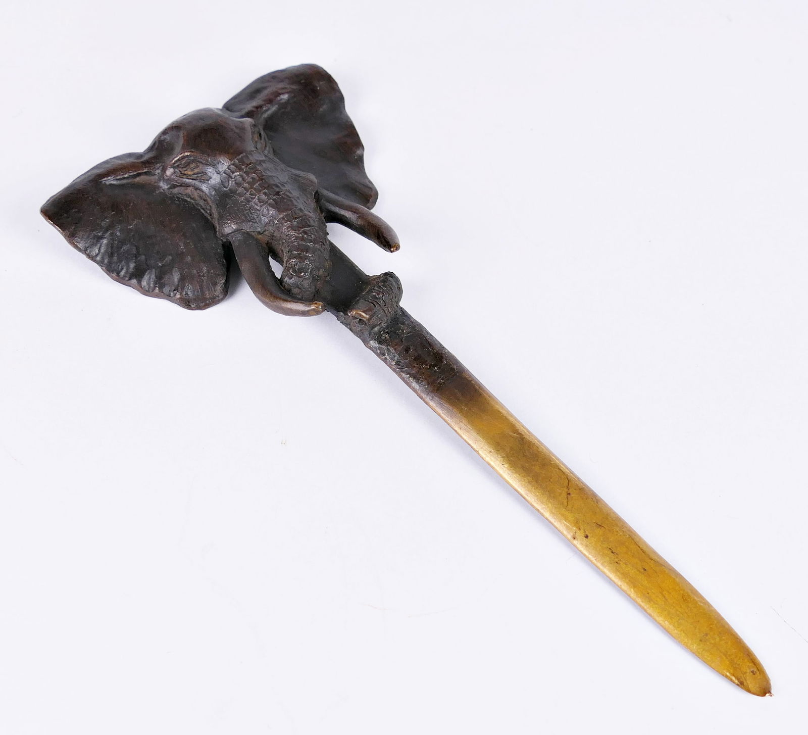 Denis Matthews Elephant Letter Opener: Bronze letter opener by Denis Matthews, circa 1993, depicting an elephant head. Made in Kenya, number 286. Surface finish shows scratches. Size: 7.5"L Location: Showcase