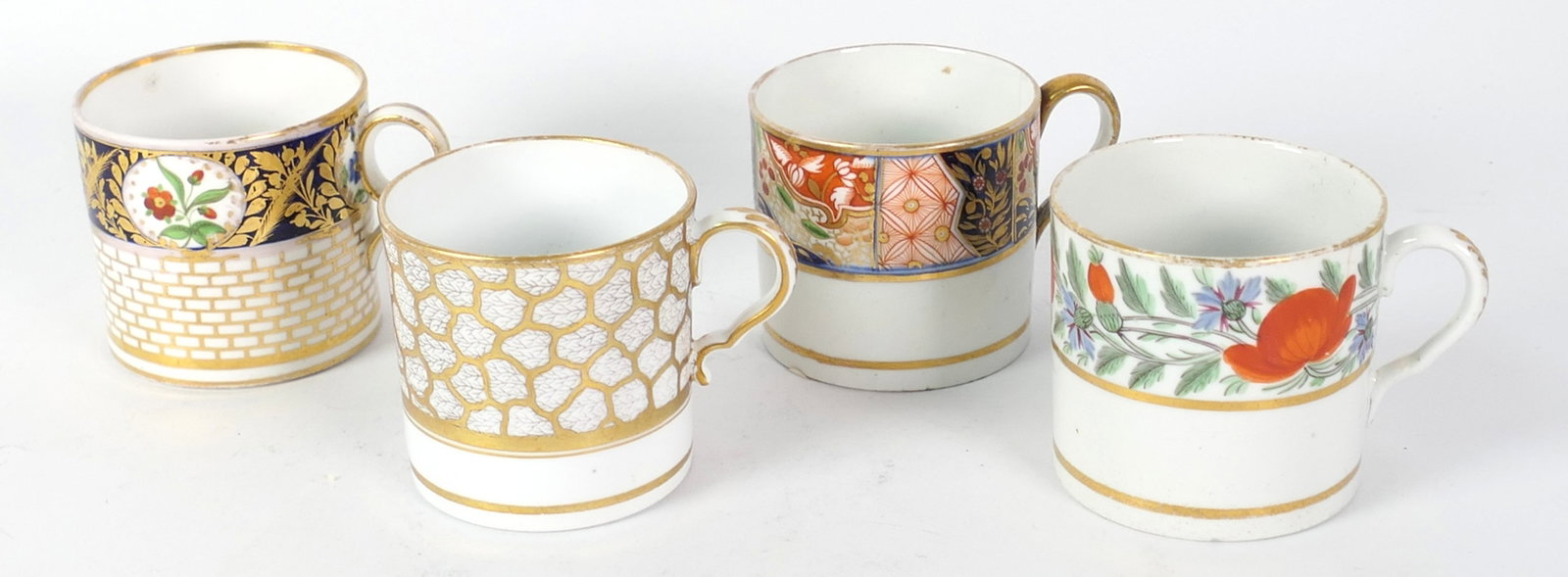 Four English Coffee Cans: Four English coffee cans in Imari and various patterns with gilded features and floral and foliate motif. One cup with interior crack, chip. Size: 2.75"dia x 2.5"h