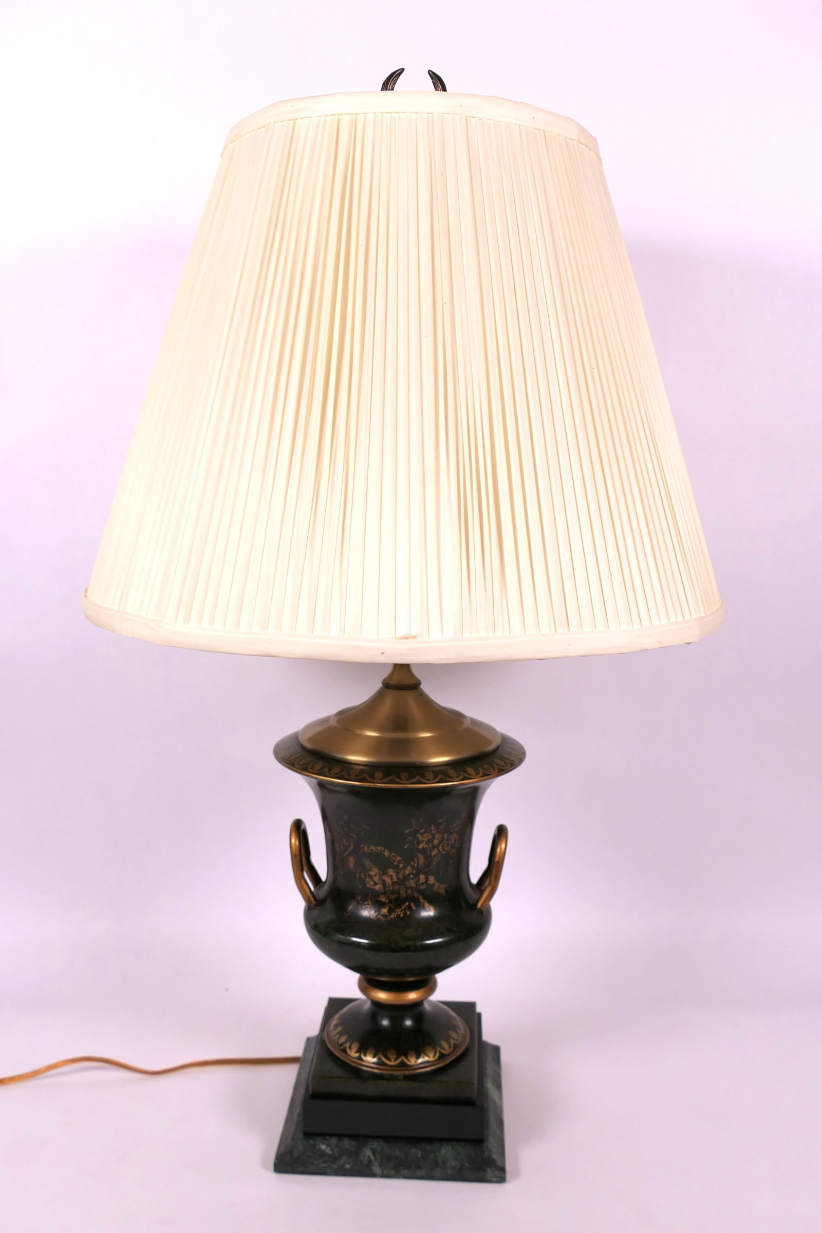 Frederick Cooper Style Metal Lamp: Vintage Frederick Cooper style lamp with metal urn shape, double handles and laurel motif on one side resting on graduated green marble base and pleated shade with 3 way switch. Lights. Size: 28"h Loc