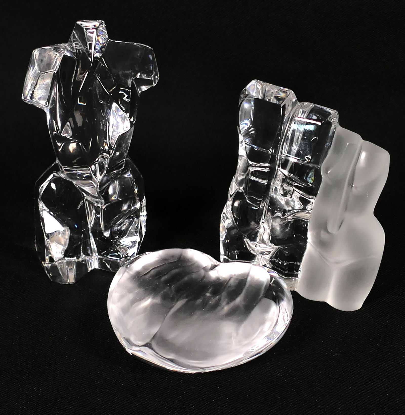 Three Daum Crystal Pieces: Three Daum crystal pieces including heart shaped paperweight featuring frosted relief hands and (2) nude figures. Marked with etched signature. Size: Largest 2"w x 4.5"h Location: Den