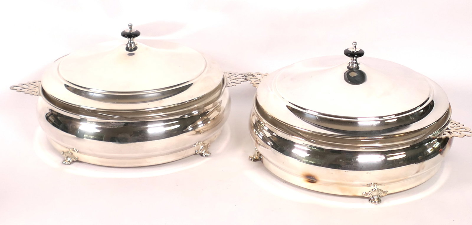 Two Round Silverplate Lidded Serving Dishes: Two round lidded silver plate serving dishes marked Crescent with Pyrex glass inserts. Size: Handle to handle 14"w x 11"d x 6.5"h Location: Kitchen