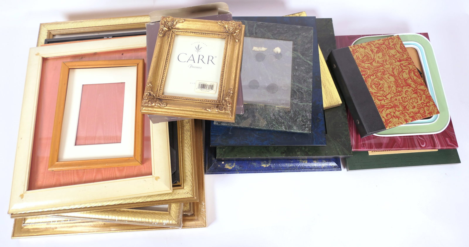 Shelf of Picture Frames: Shelf of picture frames including stone, gold tone, small photo album and more. Size: Largest 15"w x 12"h Location: Library