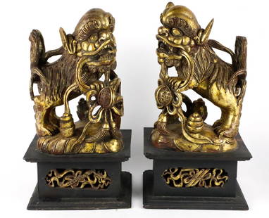 Two Carved Foo Dogs: (2) Carved gold/black Foo Dogs made of resin and wood, cracks in the wood and resin. Size: 7"w x 8.75" x 16.5"h Location: Living Room