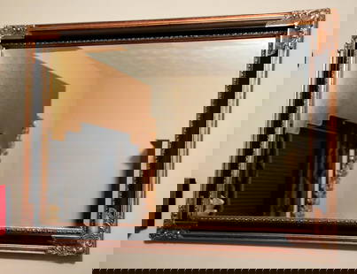 Large Decorative Wall Mirror: Large decorative antiqued gold tone and black framed wall mirror featuring beveled edges and a foliate design on the corners. Size: 3'6"w x 29"h Location: Office