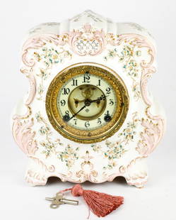 Ansonia China Clock: Pink & white Ansonia china clock made by Ansonia Clock Co. New York. Untested. Missing the latch in the back, key works in 1 hole but not the other. Size: 10.5"w x 4"d x 11.5"h Location: Lower Level S