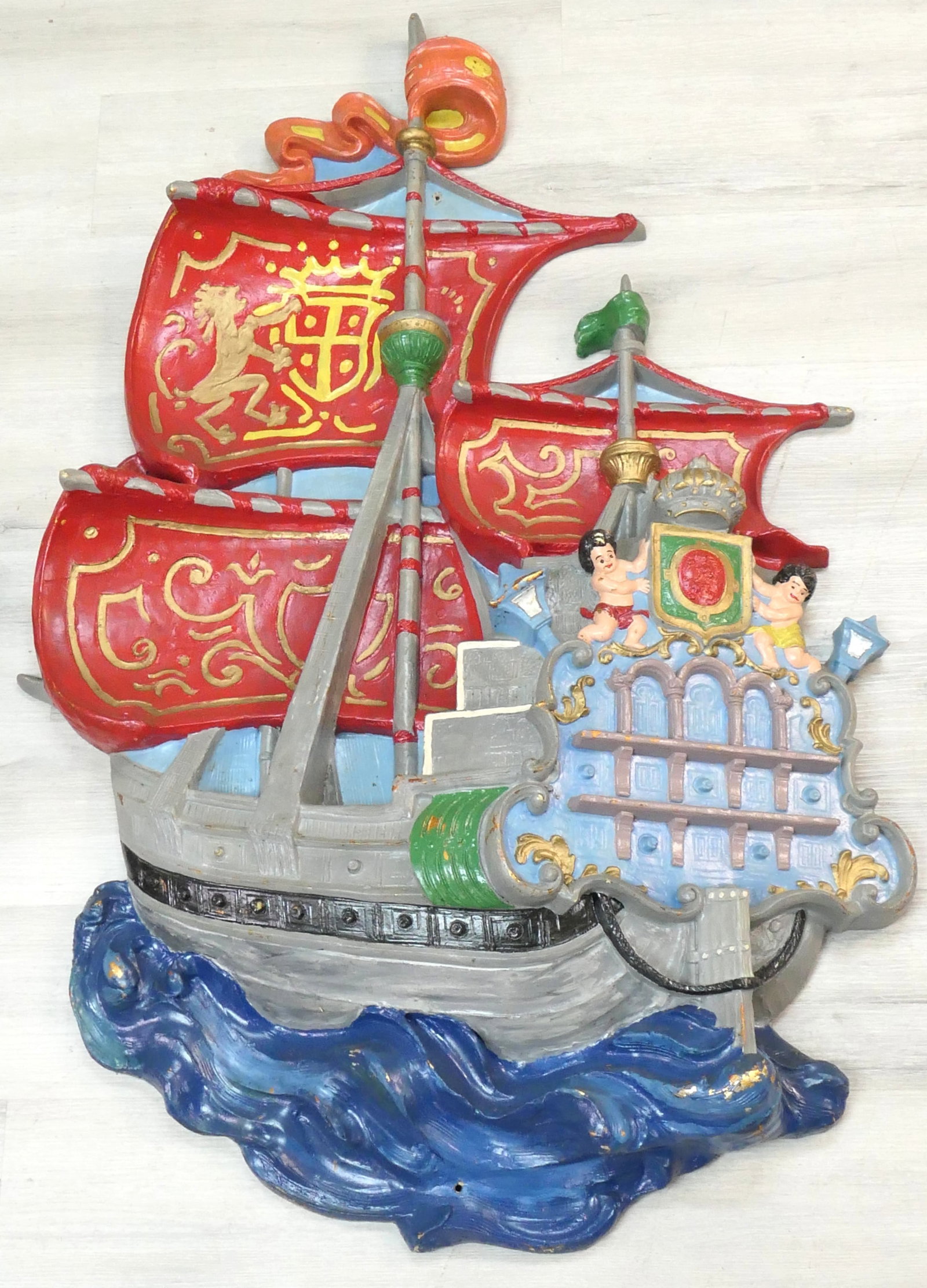 Decorative Fiberglass Ship: Decorative tall ship fiberglass wall hanging with red sails made by Triangle Products, styled in Los Angeles, CA. Color loss. Size: 24"w x 3'5"h