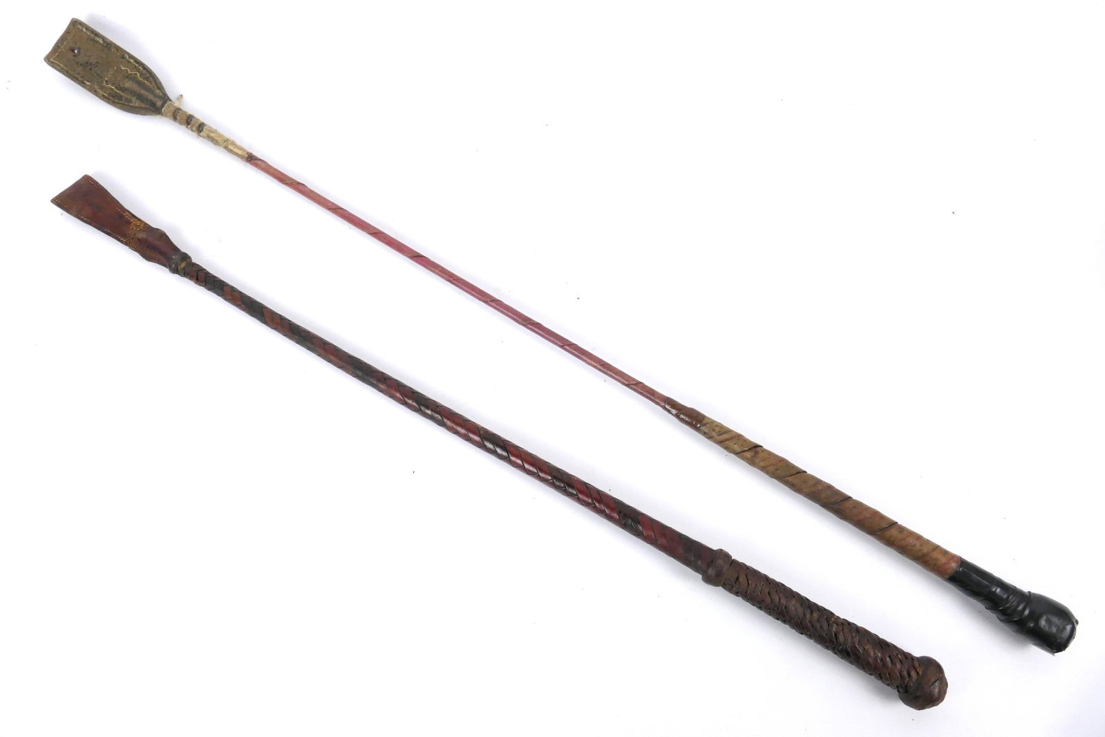 Two Vintage Riding Crops: Two vintage riding crops. One leather end is nearly torn off, the other has tape repairs on handle. Size: 1.5"w x 28.25"L