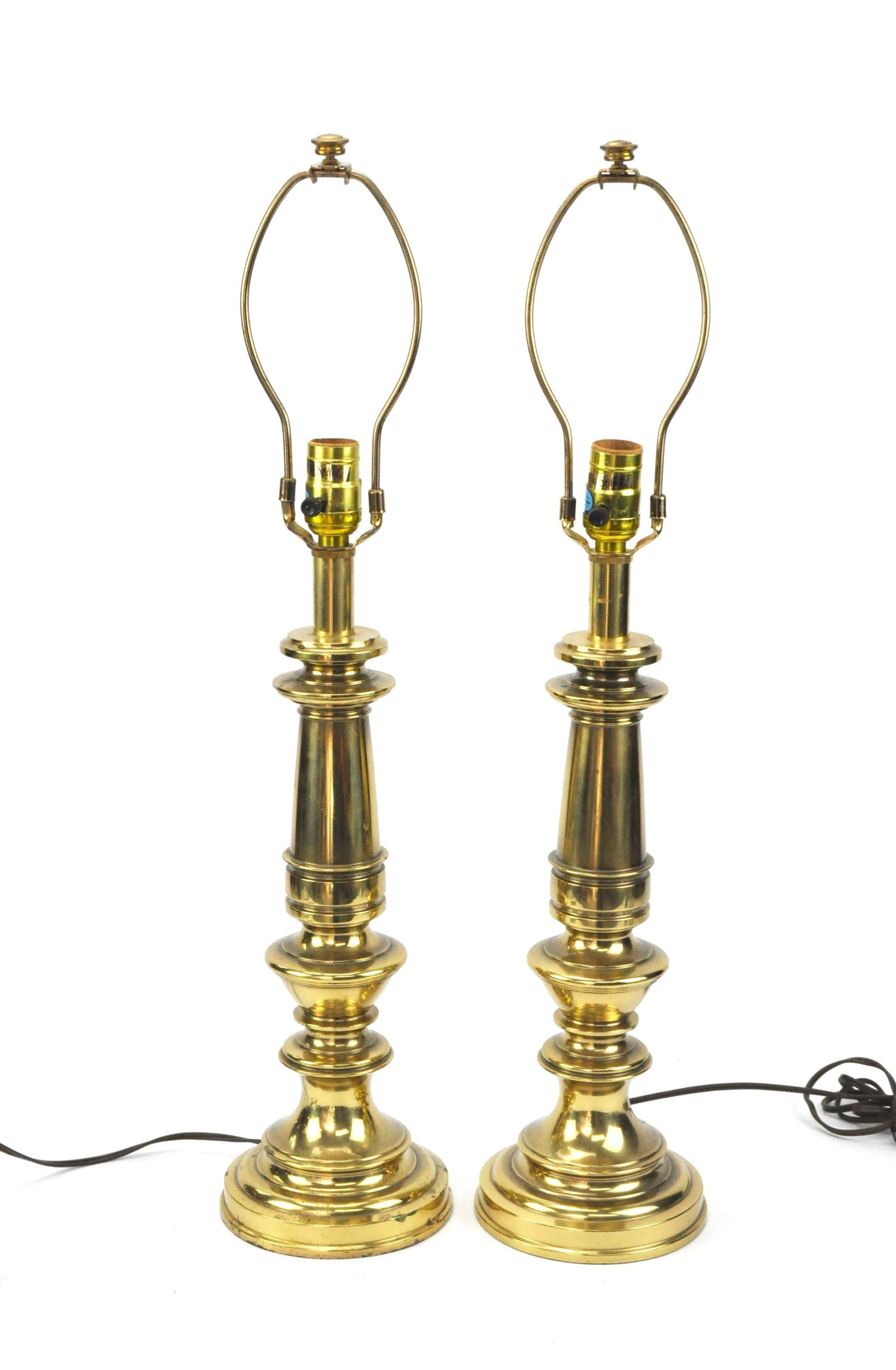 Pair of Stiffel Brass Lamps: Pair of Stiffel heavy brass lamps, with harps but no shades present. Both light. Size: 27"h