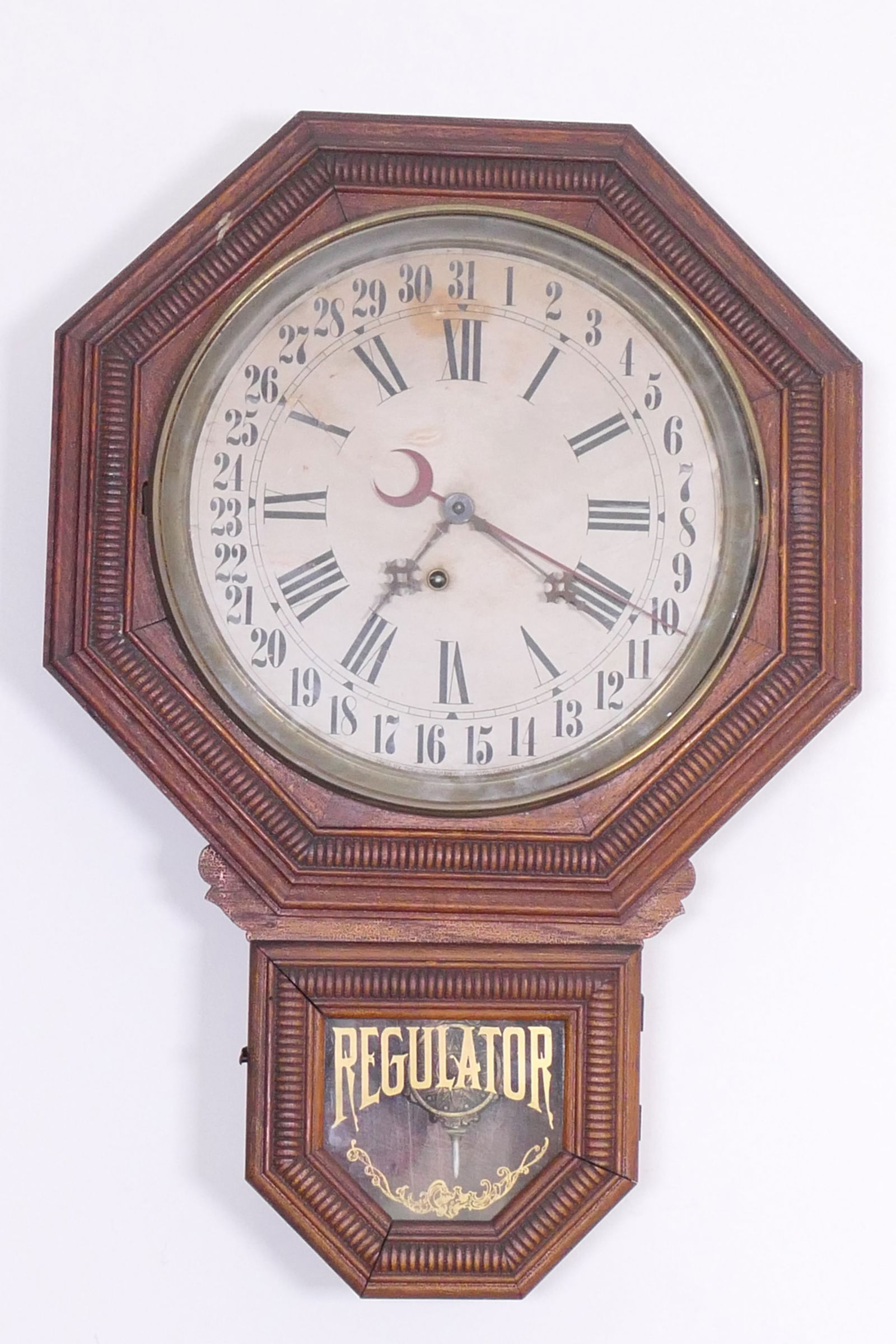 Regulator Ingraham Wall Clock: Regulator F Ingraham Co wall clock/calendar with day hand. Pendulum and key present. Winds and runs, time keeping accuracy not guaranteed. Discoloration on face. Size: 17"w x 3.5"d x 25"h Location: Li