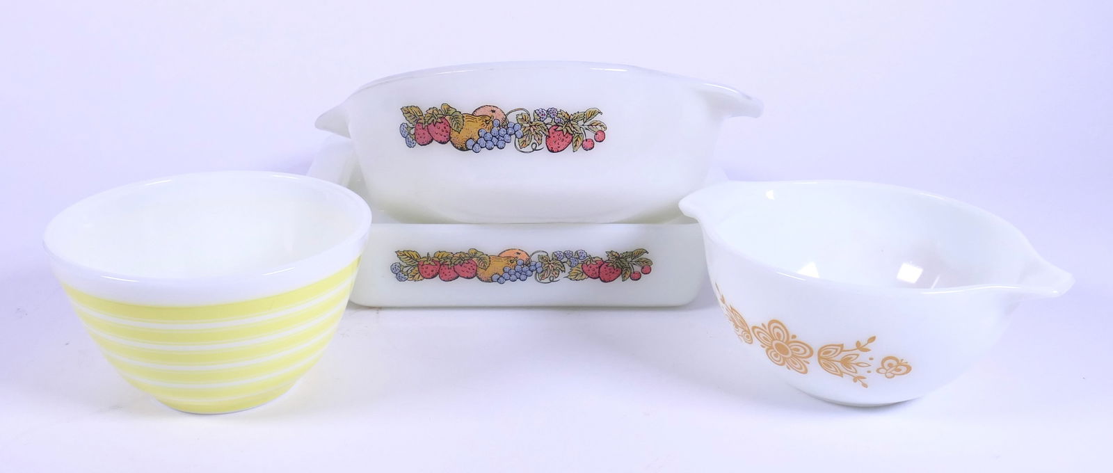 Collectible Pyrex and Fire King: Pyrex Butterfly gold Cinderella bowl, Pyrex yellow stripe mixing bowl (scratches) and (2) Fire King Nature's Bounty design (round one shows scratching in interior). Size: Largest 8" sq Location: Kitch