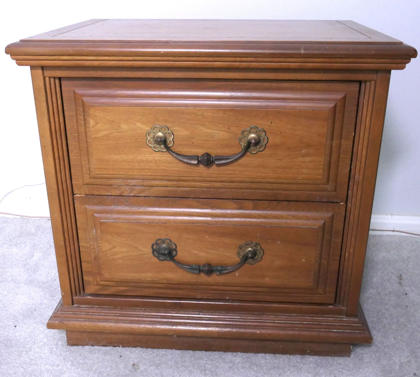 Two Drawer Nightstand: Two drawer nightstand with wide handles on stacked front design on base. Surface wear, scratches. Size: 24"w x 16"d x 23"h Location: Upstairs Bedroom