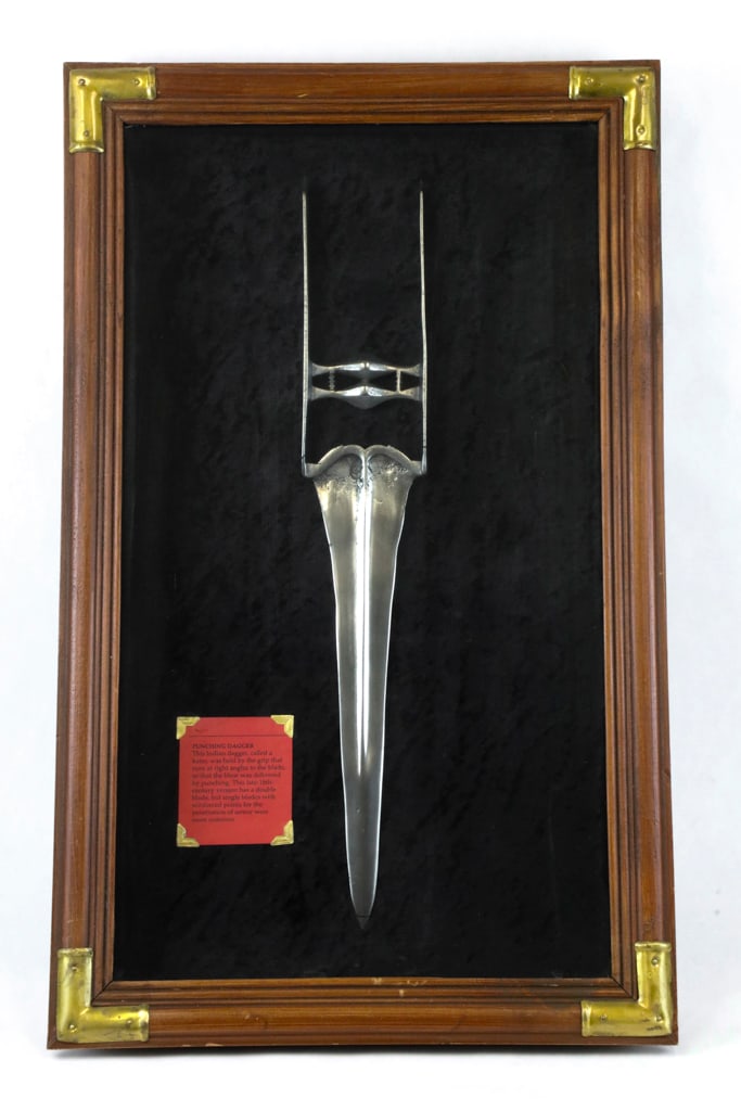 Double-Edged Punching Dagger or Katar in Frame Circa 1790: Punching dagger or katar from India is circa 1790 and has a double-edged blade with H-shaped horizontal grip. Size: Frame: 13.35"w x 21.50"h Dagger: 17"l approx.