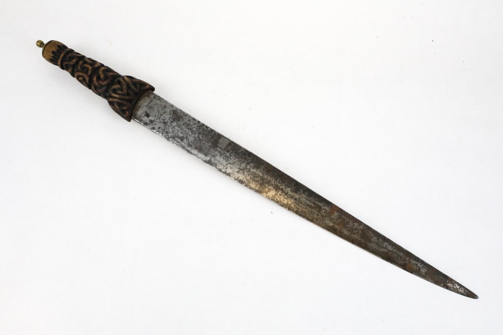 Carved Ornate Wood Handle Pommel Dagger: Carved ornate wood handle pommel dagger, or short saber. Featuring a design that resembles celtic knotwork in the interlaced carving. The blade is thick and shows minor rust. Size: Blade: 17"l, Full L