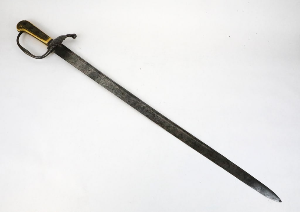 18th Century German Hunting Sword: 18th Century German hunting sword with prominent shell guard. Featuring a 'D' shaped knuckle bow, and staghorn handle riveted to the sword. An engraving is shown, and has wear from the age. Size: Blad