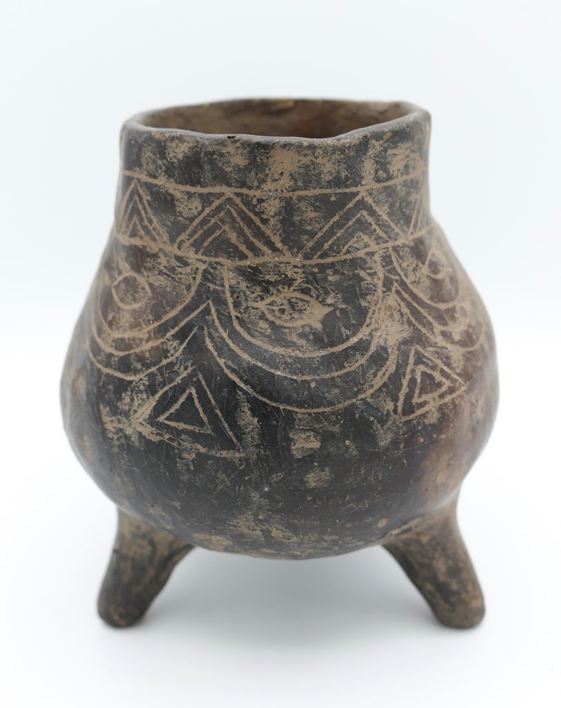 Pre-Columbian Tripod Leg Pottery Vessel: Pre-Columbian tripod leg pottery vessel featuring a geometric carving. The marks and imperfections show that this was handcrafted. Size: 4"dia x 4.5"h