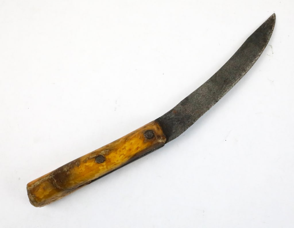 Antique Buffalo Skinning Knife: Double edge dagger with brass guard and bone like handle. The blade edges are dull, and the dagger is very symmetrical in appearance. The scabbard is a homemade wooden holder with damage to the point