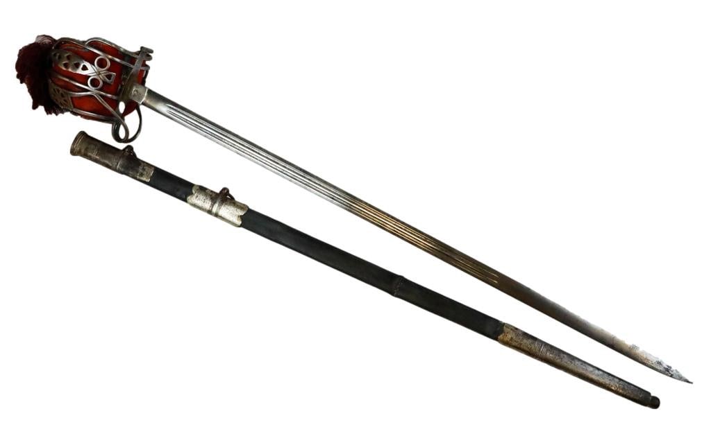 Scottish Basket Hilt Sword with Maroon Tassel: Scottish basket hilt sword with a silvertone pierced design, with a fitted pocket to protect your hand from contact. There is an aged leather handle with a braided brass wire and finial pommel with a