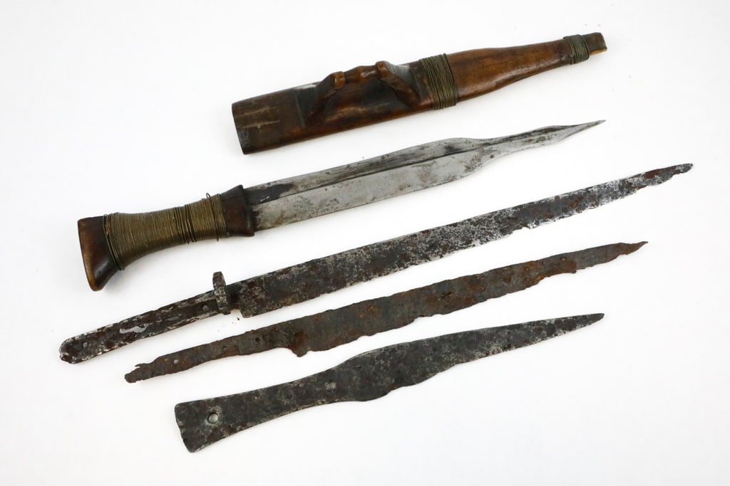 Three Antique Knife Blades and One Knife in Sheath: Three antique knife blades, show pitting and rust. One knife has a wire-wrapped handle missing wood at the base and is in a split wooden sheath with its own carved handle and wire wrapping detail. Siz