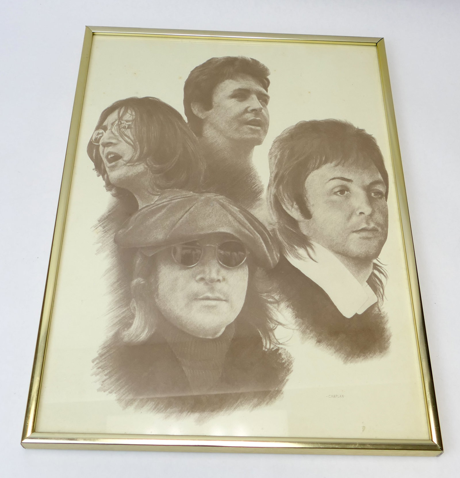 Framed Beatles Art Print: Framed art print by AbleArt depicting The Beatles in pencil-drawn style. The back is marked with a certificate labeling the piece with the serial # 219ODT. Framed in a gold tone metal frame. Size: