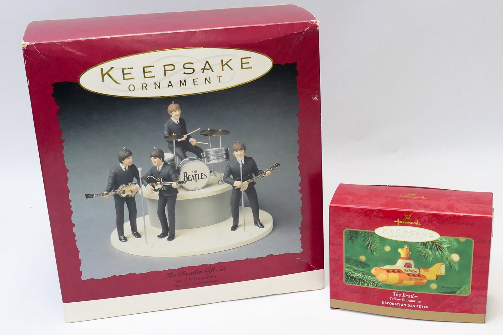 Beatles Christmas Ornaments: Two Hallmark Keepsake ornaments themed for The Beatles, including a large multi-part ornament of The Beatles playing, and a smaller Yellow Submarine ornament. Both are kept in original boxes. The