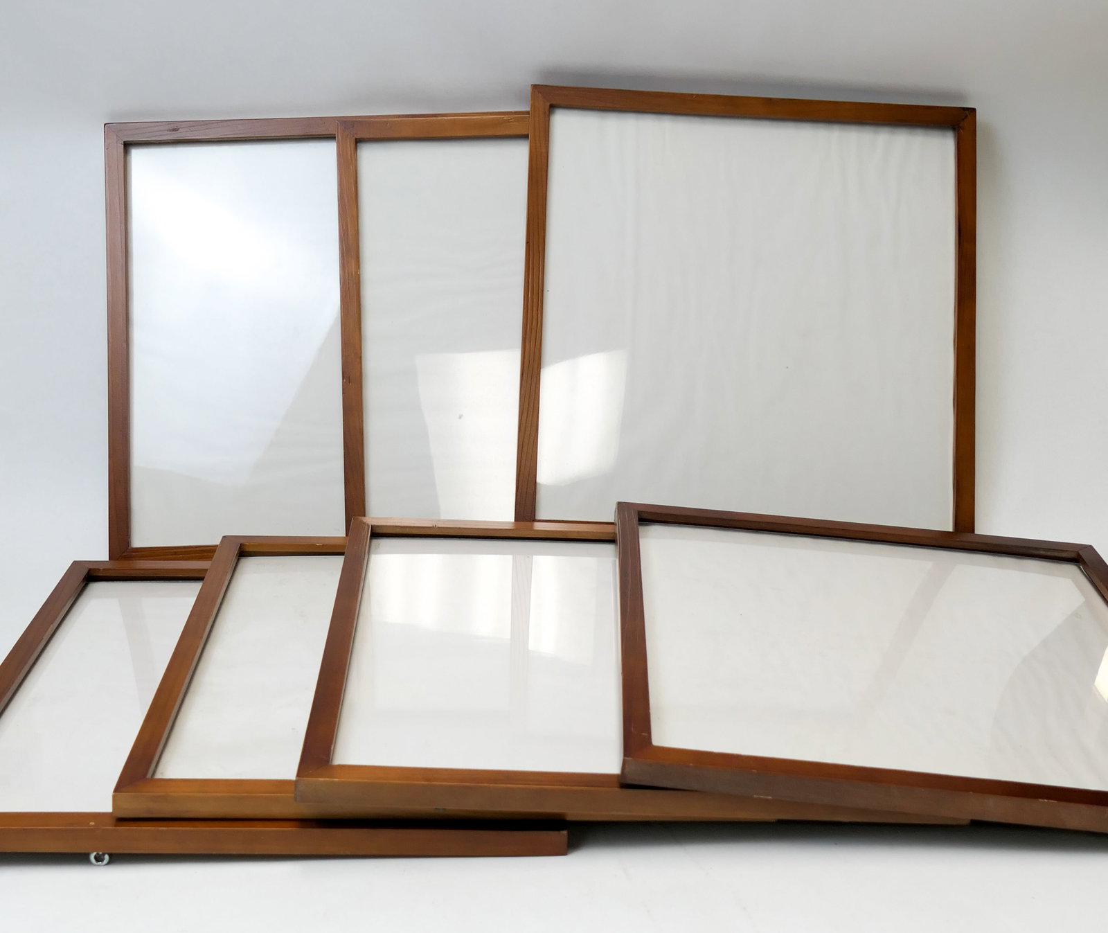 Seven Record Frames: Seven frames meant to display a 33RPM record sleeve. All show wood frame edges and glass panes. Size: 13.25"sq