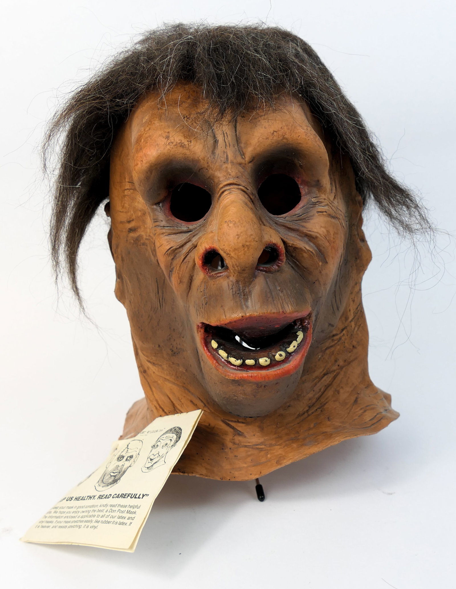 Don Post Studios Caveman Mask: Soft vinyl Halloween mask by Don Post Studios, depicting a caveman. Original tag is attached. Some hair is shedding. Marked on the back of the neck Don Post 1981. Size: Approx 12.5"h