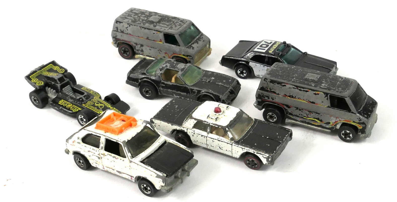 Collection of Back and White Hot Wheels: Collection of black and white Hot Wheels vehicles including a Hare Splitter (missing a wheel), a 1973 Formula Pack, a sheriff car and police cruiser, a Super Bus, and more. Many show significant wear