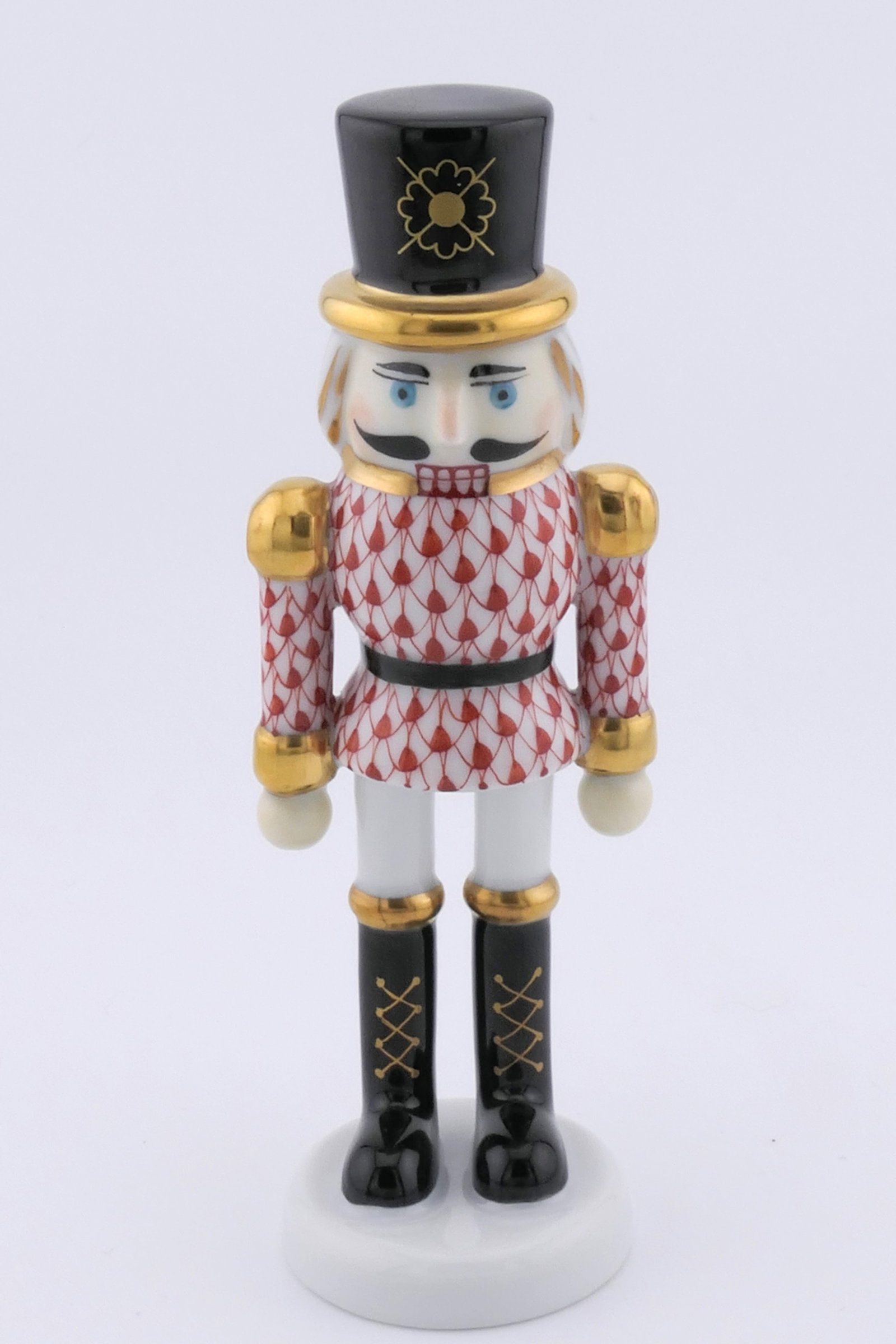 Herend Nutcracker Figurine: Marked Herend porcelain figurine featuring a nutcracker design in rust fishnet patterning. Marked on the bottom with the Herend insignia. Excellent condition. Size: 1.5"dia x 4.5"h Location: Living
