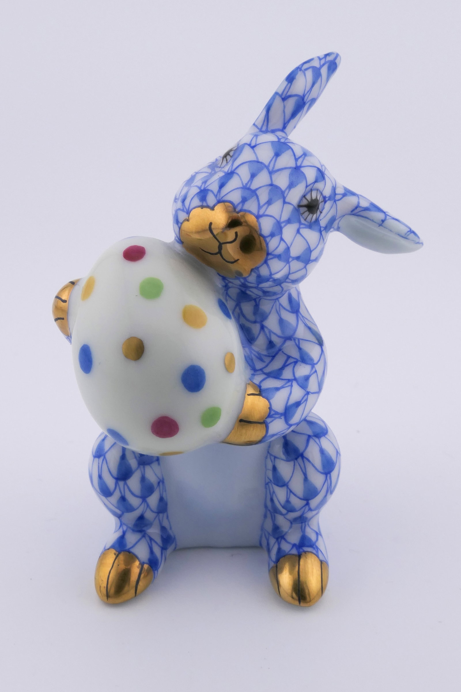 Herend Easter Rabbit Figurine: Marked Herend porcelain figurine featuring a rabbit design holding an easter egg in blue fishnet patterning. Marked on the bottom with the Herend insignia. Excellent condition. Size: 1.25"sq x 2.5"h