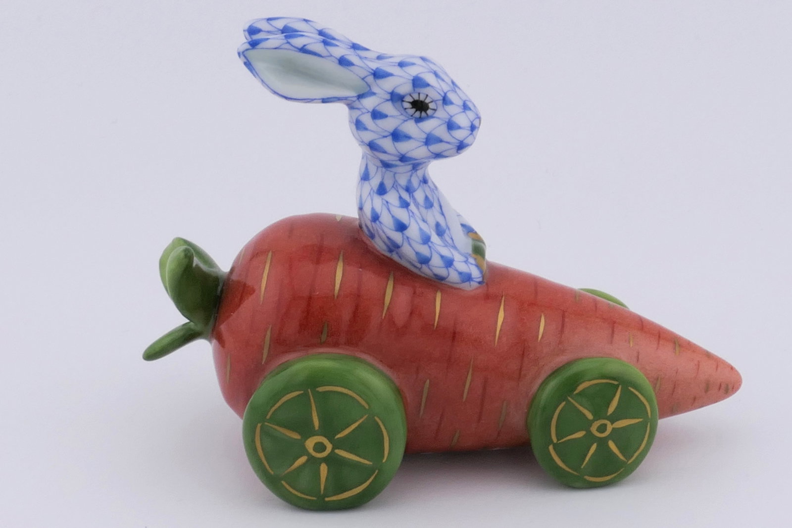 Herend Carrot Car Rabbit Figurine: Marked Herend porcelain figurine featuring a rabbit design in blue fishnet patterning driving a carrot car. Marked on the bottom Herend, Hungary. Excellent condition. Size: 1.75"w x 3.5"d x 2.5"h
