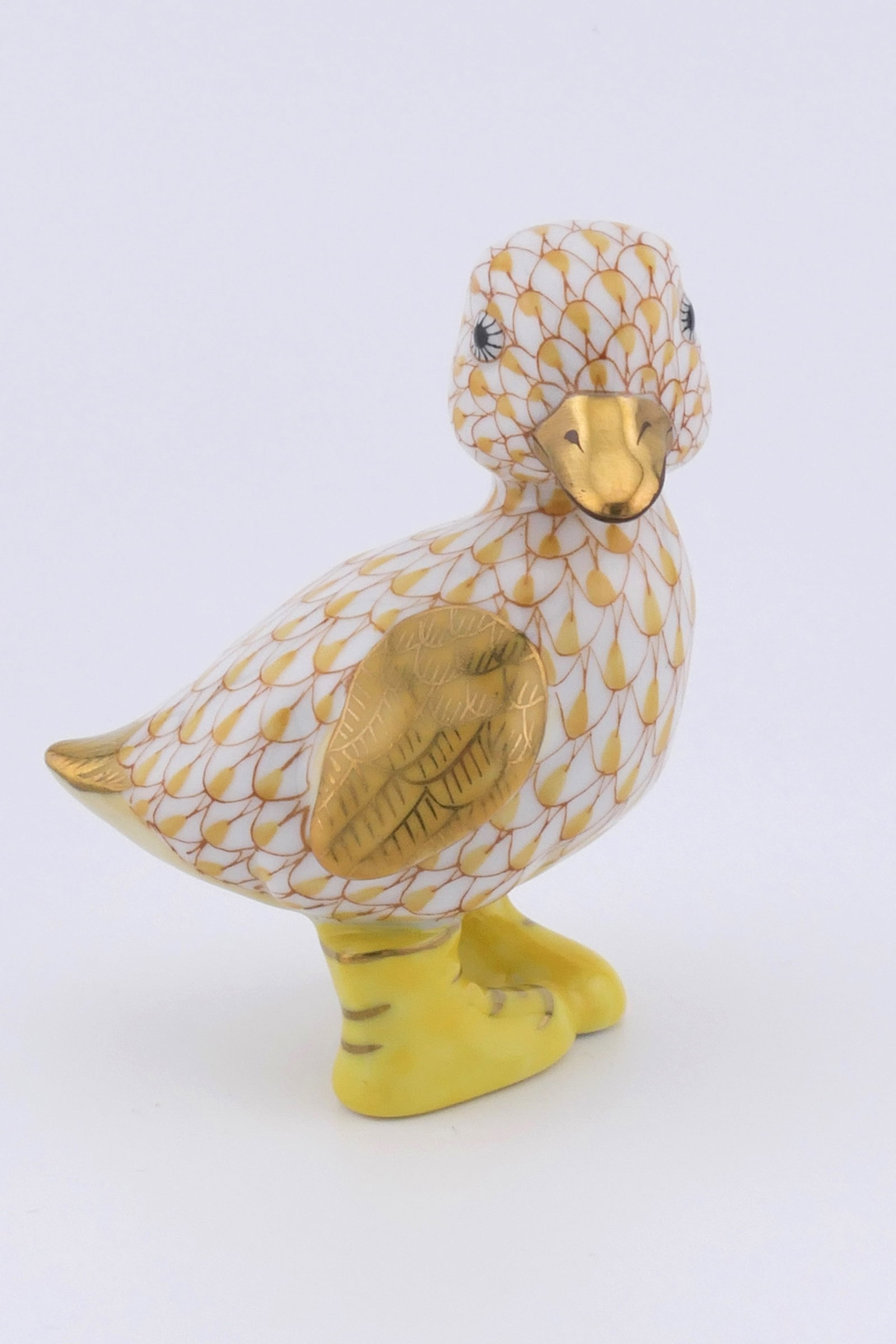Herend Rainboots Duckling Figurine: Marked Herend porcelain figurine featuring a duckling design in butterscotch fishnet patterning wearing rainboots. Marked on the bottom with the Herend insignia. Excellent condition. Size: 1.25"w x
