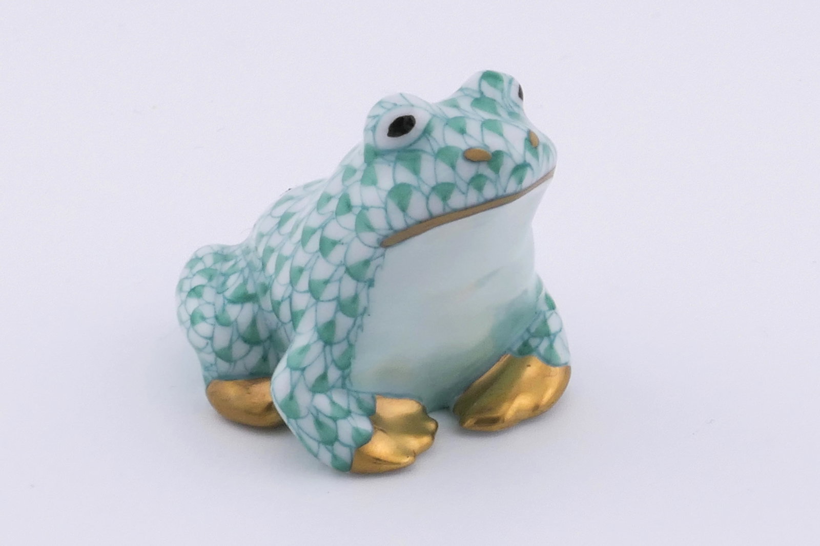Herend Frog Figurine: Small marked Herend porcelain figurine featuring a frog design in green fishnet patterning with gold tone accents. Marked on the bottom with the Herend insignia. Excellent condition. Size: 1.5"sq x