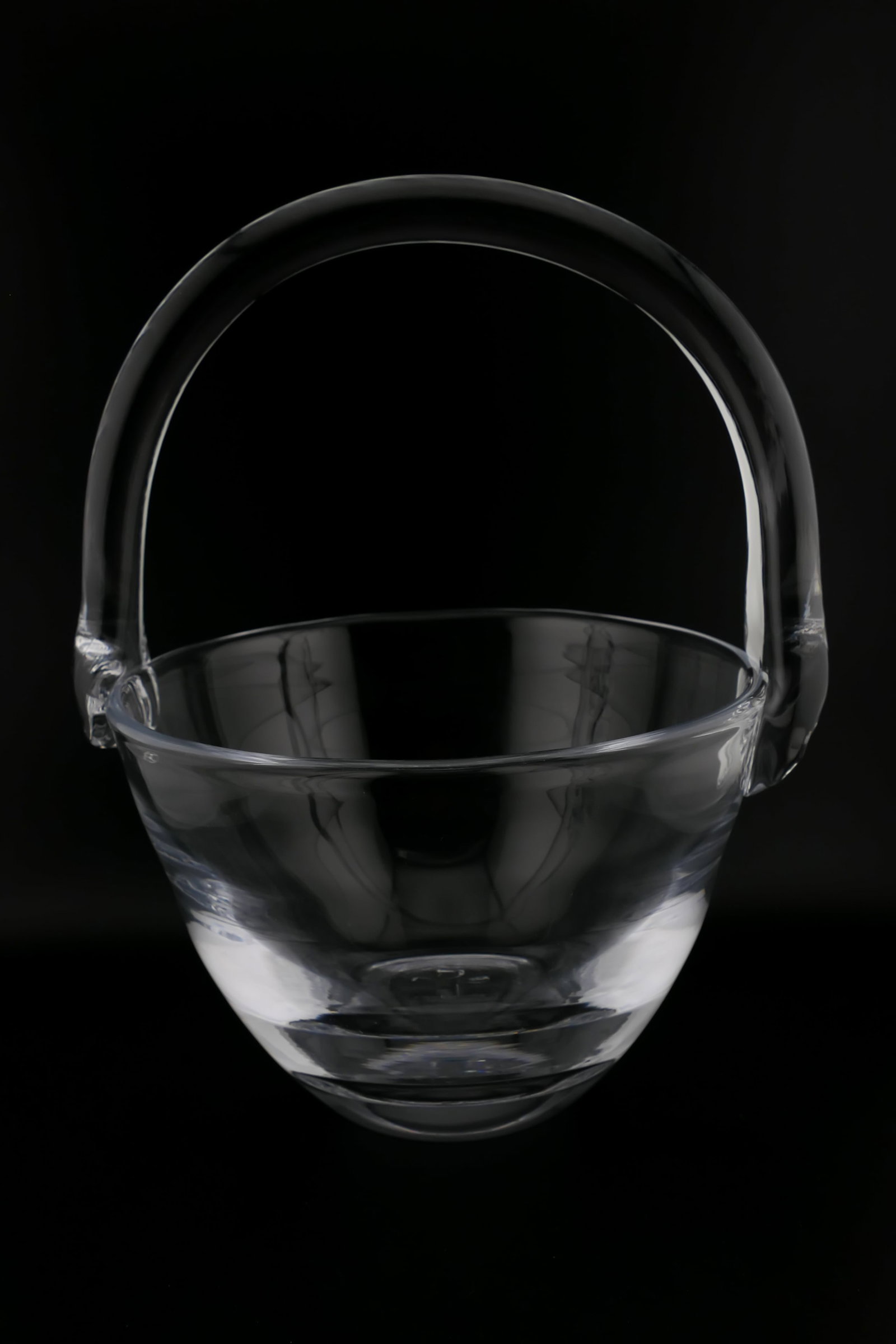 Simon Pearce Crystal Basket: Marked Simon Pearce crystal basket featuring an applied handle. Signed Simon Pearce with a clover leaf loop and accents. Excellent condition. Size: 7"dia x 9"h Location: Living Room