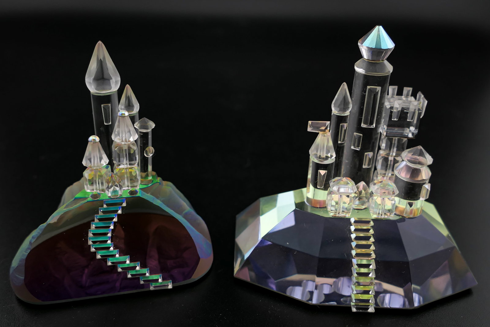 Crystal Castle Figurines: Two unmarked crystal figurines depicting castles on iridescent bases. Good condition with one flag showing glue residue. Size: Taller 2"h Location: Living Room