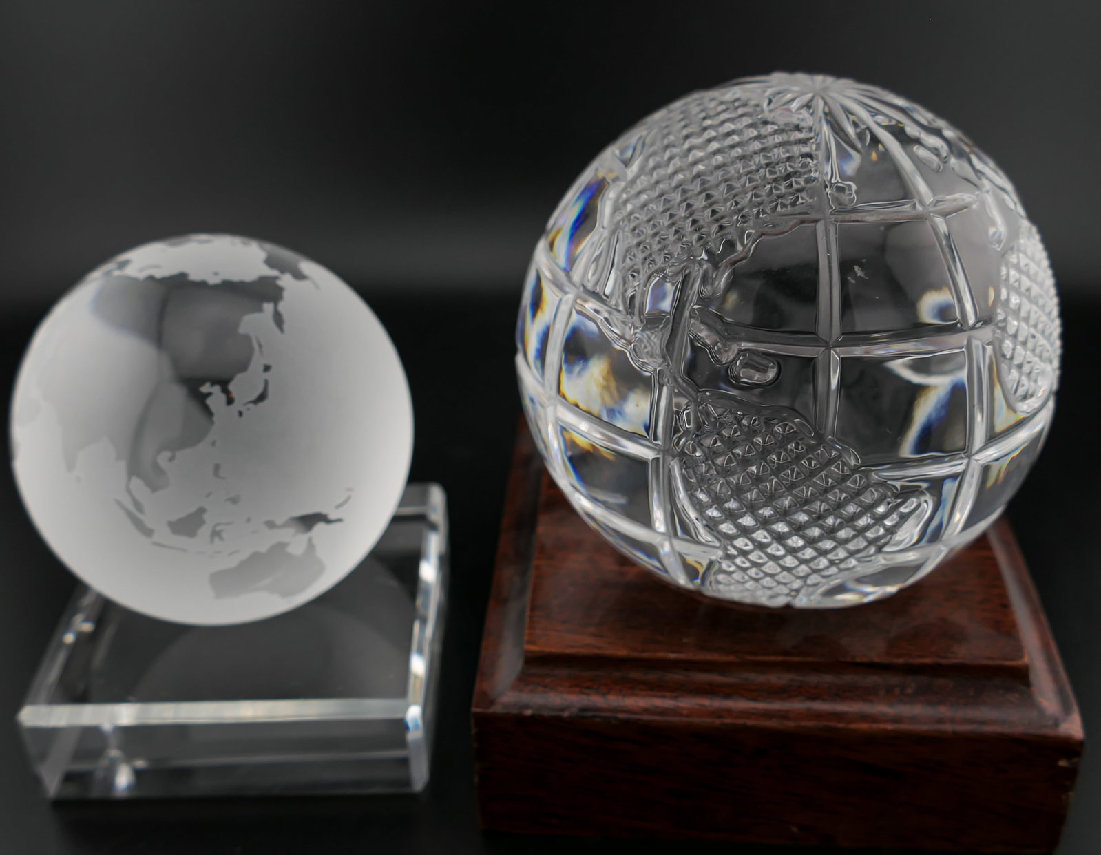 Tiffany & Co Crystal Globe: Tiffany & Co. crystal globe featuring frosted accent continents and a round crystal base, alongside a Waterford crystal globe on a wooden base. The frosted globe is etched on the base for Tiffany & Co