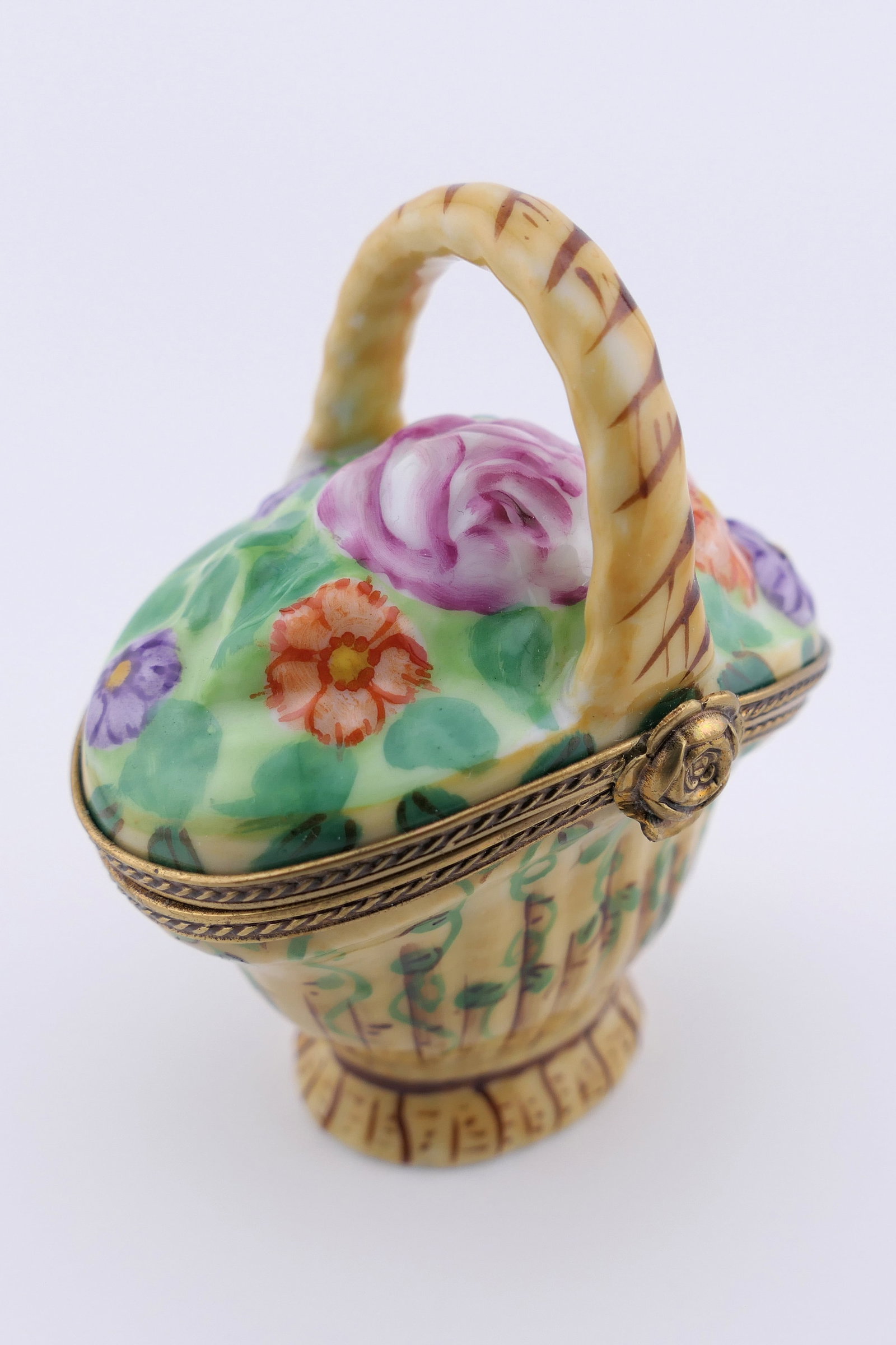 Limoges Porcelain Flower Basket Trinket Box: Marked Limoges hand painted porcelain hinged trinket box featuring a design of a basket of colorful flowers. Marked on the bottom Limoges France. Excellent condition. Size: 2.5"w x 3"h Location: Livin