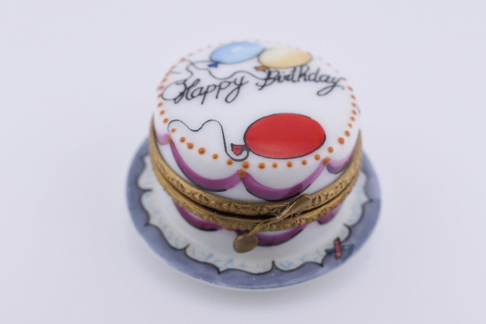Limoges Porcelain Birthday Cake Trinket Box: Marked Limoges hand painted porcelain hinged trinket box featuring a birthday cake design with garland motifs. Marked on the bottom Limoges France, and numbered 1622/2000. Excellent condition. Size: 1