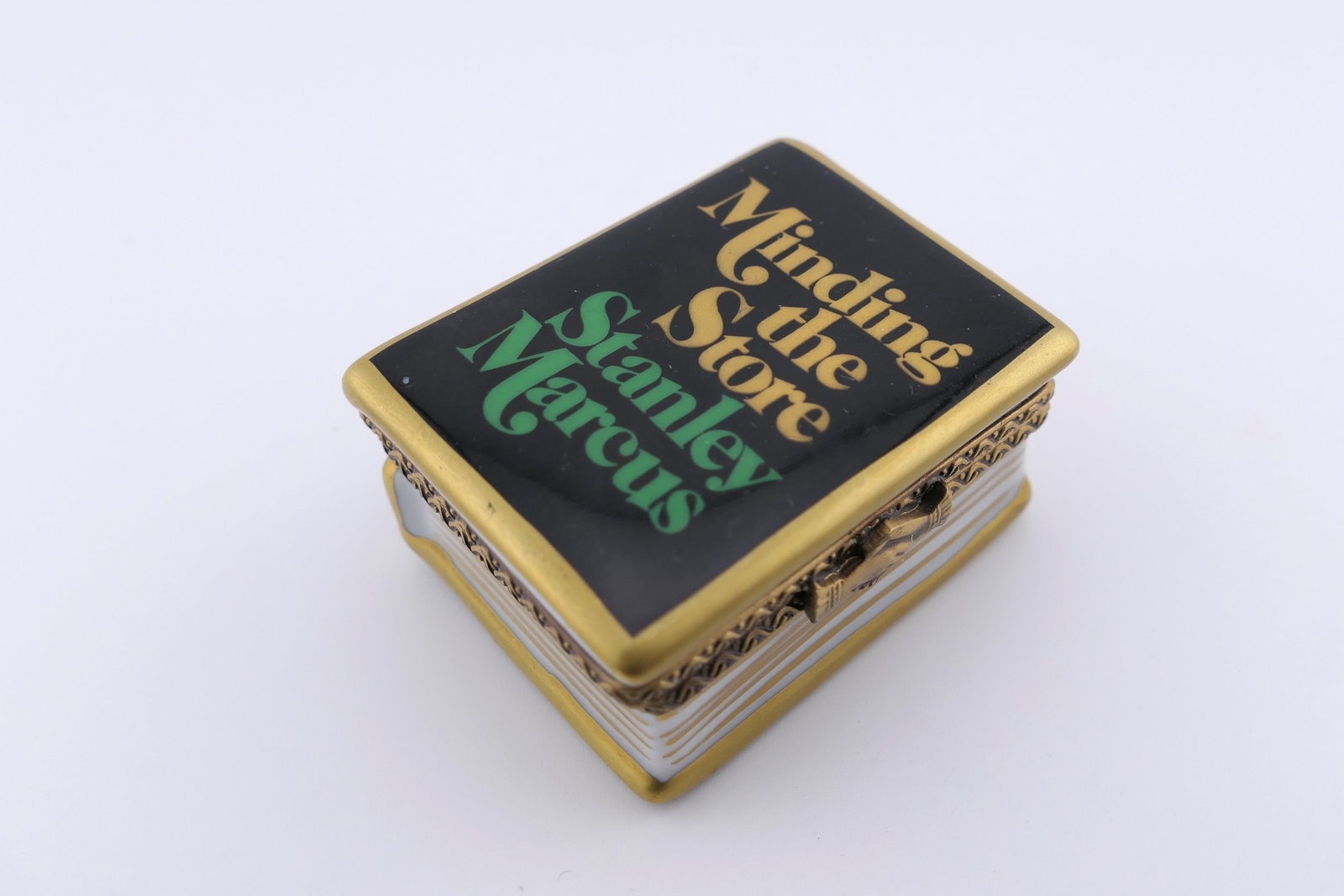 Limoges Porcelain Neiman Marcus Book Trinket Box: Marked Limoges hang painted porcelain hinged trinket box featuring a book design branded for Neiman Marcus. Marked on the inside Limoges France, Neiman Marcus. Size: 1.75"w x 1.25"d x 1"h Location: Li