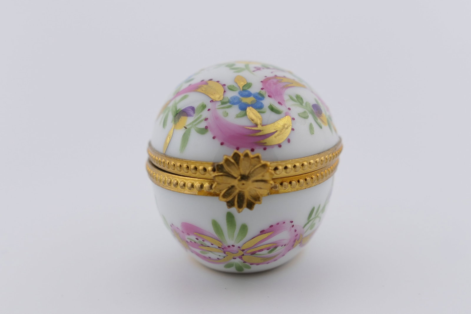 Limoges Porcelain Egg Trinket Box: Limoges hand painted porcelain trinket box featuring an egg-shaped design with floral and gilt motifs. Marked on the bottom Limoges France. Excellent condition. Size: 1.5"w 2.5"d x 1.5"h Location: Liv