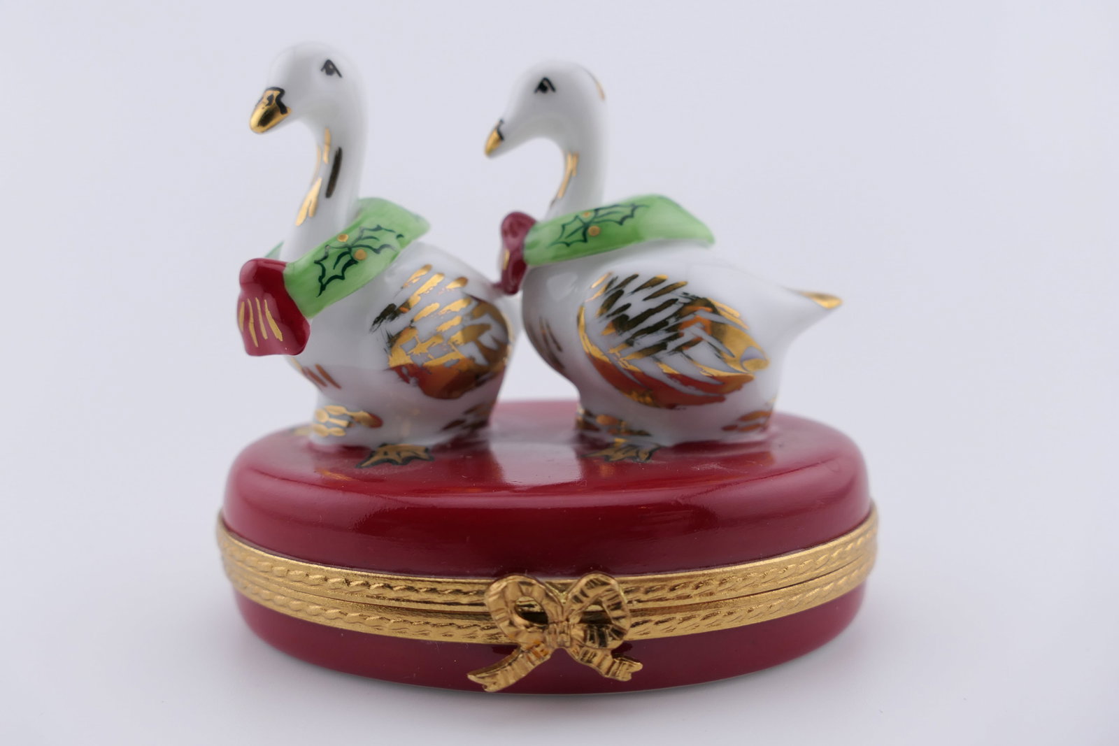 Limoges Porcelain Christmas Geese Trinket Box: Limoges hand painted porcelain hinged trinket box featuring a design of two Christmas geese with wreaths on their necks. Marked on the bottom Limoges France, 43/750. Excellent condition. Size: 2.5"w x