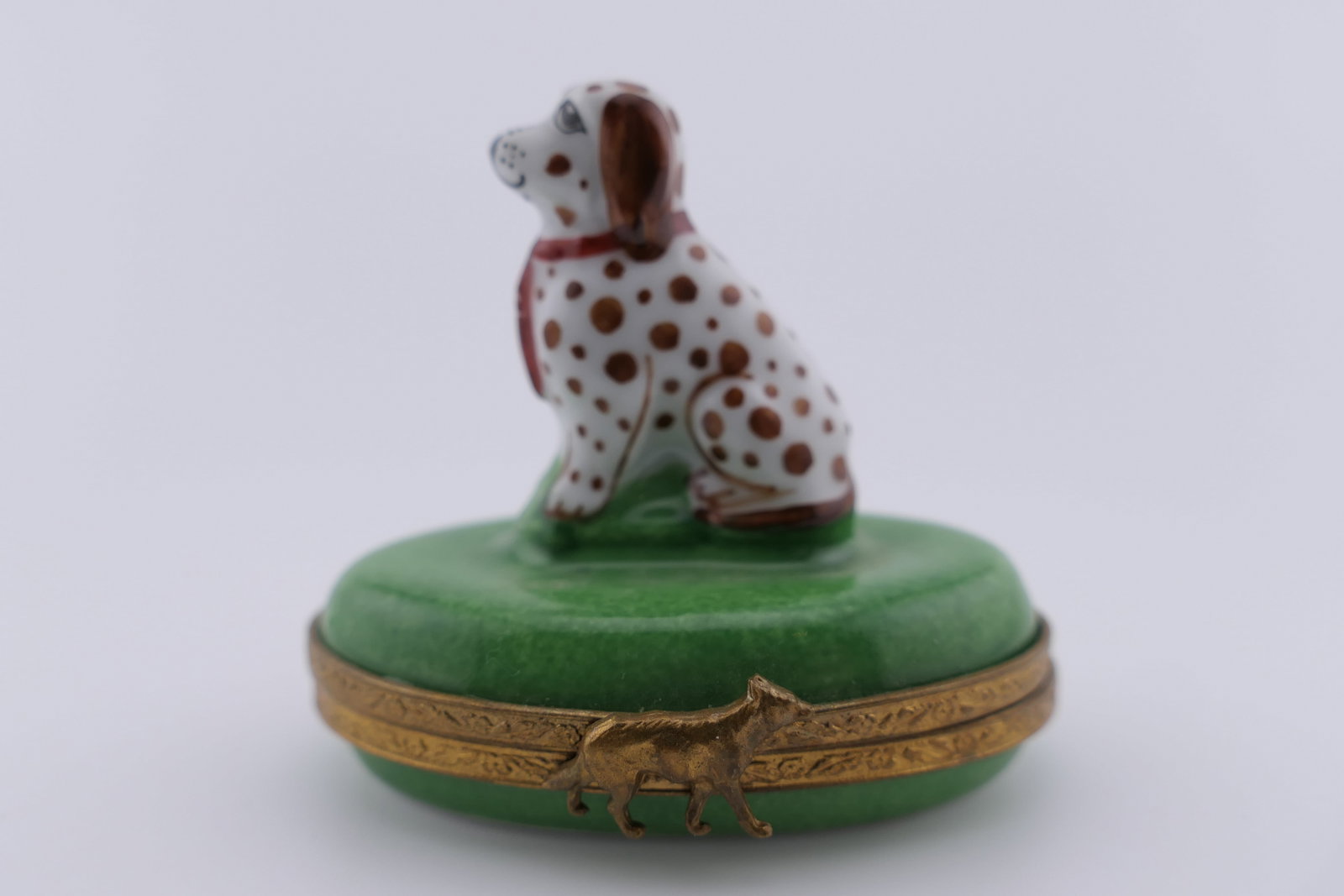 Limoges Porcelain Puppy Trinket Box: Limoges hand painted porcelain hinged trinket box featuring a design of a puppy wearing a necktie. Marked on the bottom Limoges France. Excellent condition. Size: 2.25"w x 1.5"d x 2"h Location: Living